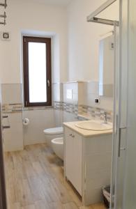 a white bathroom with a toilet and a sink at B&B Baroi Orgosolo in Orgosolo +23 photos