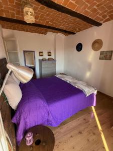 ein Schlafzimmer mit einem lila Bett in einem Zimmer in der Unterkunft View & Wine Room in Canelli