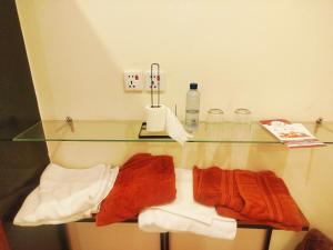 a glass shelf in a bathroom with towels on it at The Warmer House Islamabad Airport in Islamabad +30 photos