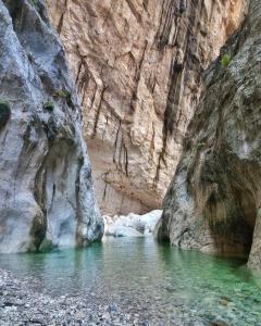 a pool of water in front of a rock wall at B&B Baroi Orgosolo in Orgosolo