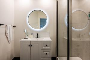 ein weißes Badezimmer mit Waschbecken und Spiegel in der Unterkunft Lofts Le Petit Champlain in Québec + 43 Fotos