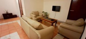 a living room with two chairs and a tv at Shillong Serviced Apartment in Shillong