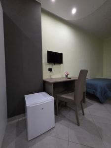 a room with a desk with a chair and a television at Hotel Rodian in Acquappesa
