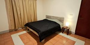 a bedroom with a bed with a black blanket at Shillong Serviced Apartment in Shillong