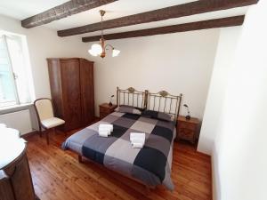 a bedroom with a bed with a black and gray blanket at Appartamento Palazzo Gattolini Venzone in Venzone