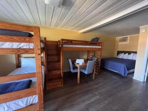 a room with bunk beds and a table and a bed at CMI Hotel 1935 Myrtle Beach SC in Myrtle Beach