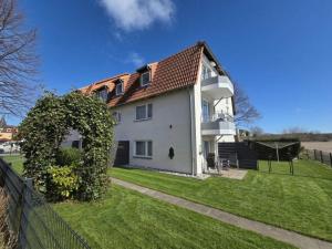 a large white house with a green yard at NEU Apartmenthaus-Usedom Familie Stopp Kajüte 7 - Balkon - strandnah in Kölpinsee