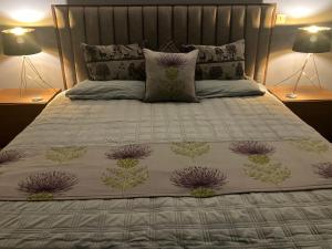 a bed with a white comforter and two lamps at Strath View on the NC 500 in Culbokie