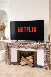 a television on top of a fireplace in a living room at MEEY Suite with Private Spa in Saint-Étienne
