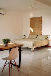a bedroom with a bed and a wooden table at Casa Mura in Puerto Escondido