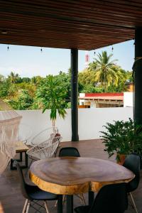 a patio with tables and chairs and palm trees at Casa Mura in Puerto Escondido