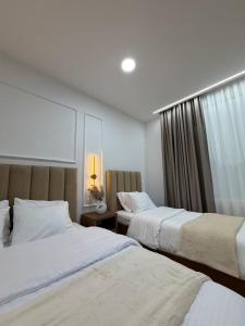 a hotel room with two beds and a window at Loris Rooms in Yrshek