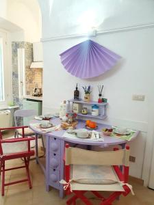 a kitchen with a table with a purple umbrella at Casa Santiago in Alassio