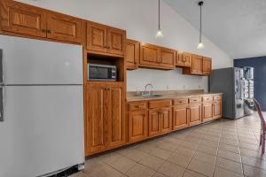 a kitchen with wooden cabinets and a white refrigerator at Indiana Beach Hotel in Monticello