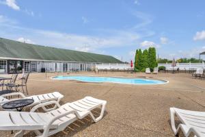 a group of white lounge chairs and a swimming pool at Indiana Beach Hotel in Monticello +15 photos