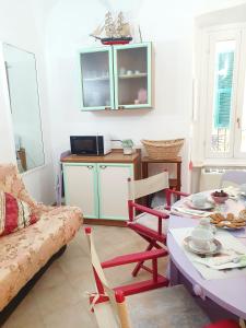 a living room with a couch and a table with chairs at Casa Santiago in Alassio