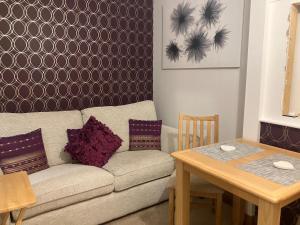 a living room with a couch and a table at Strath View on the NC 500 in Culbokie