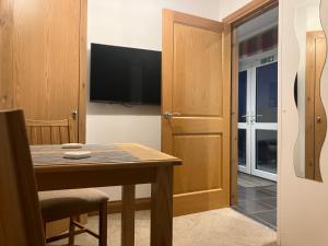a dining room with a table and a television at Strath View on the NC 500 in Culbokie