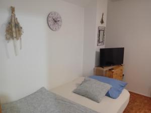 a bedroom with a bed and a clock on the wall at Sklep U Petra in Velké Bílovice