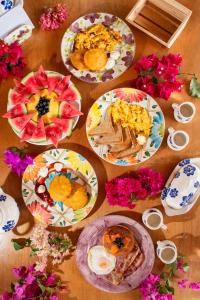 a wooden table with plates of food on it at AMALIFE Beach Club & Hotel in Tierra Bomba