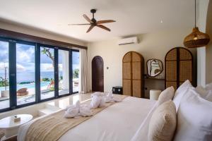 a bedroom with a large bed with a view of the ocean at Villa Kai Nusa Penida in Sampalan +39 photos