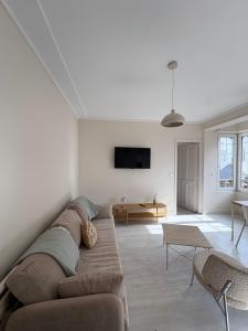 a living room with a couch and a tv at L'Eclat Marin échappée mer in Étretat