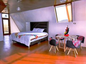 a bedroom with a bed and a table with chairs at Jutma Titicaca Lodge in Puno