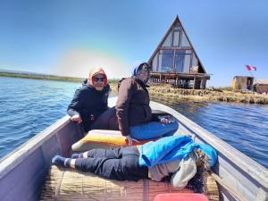 three women sitting in a boat on the water at Jutma Titicaca Lodge in Puno +1 photo