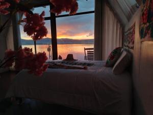 a bed in a room with a view of the ocean at Jutma Titicaca Lodge in Puno