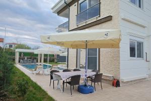 a patio with a table and chairs and an umbrella at Vıllaozden in Belek