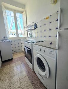 a kitchen with a stove and a washing machine at La Casetta Sul Corso in Ischia Town