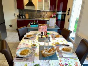a table with plates of food on it in a kitchen at Greg House 49 - Chambres d'Hôtes in Beaupréau