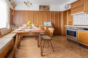 a kitchen with a wooden table with chairs and a stove at Ferienhaus Englbrecht in Krispl