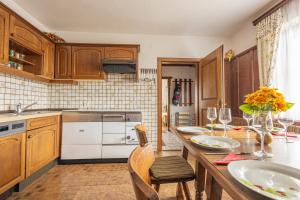 a kitchen with wooden cabinets and a table with chairs at Ferienhaus Englbrecht in Krispl +42 photos