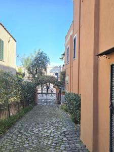 a cobblestone street in an alley between two buildings at La Casetta Sul Corso in Ischia Town