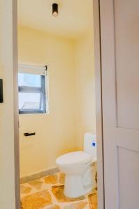 a bathroom with a toilet and a window at Makáry Beach Tolú by Bernalo Hotels in Tolú