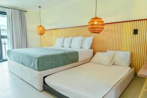 a hotel room with two beds and two lamps at Makáry Beach Tolú by Bernalo Hotels in Tolú