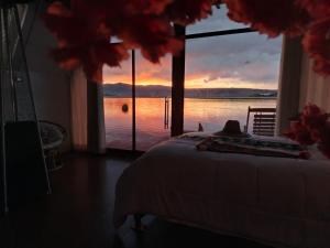 a bedroom with a bed and a view of the water at Jutma Titicaca Lodge in Puno