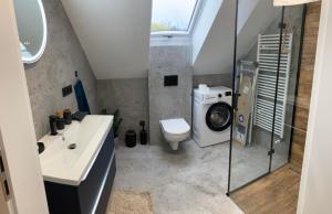 a bathroom with a sink and a washing machine at Szumny Apartment 13a in Brzozówka +29 photos