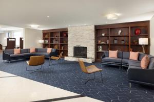 a lobby with couches and chairs and a fireplace at Courtyard by Marriott Montvale in Montvale