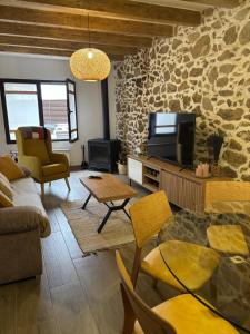 a living room with a stone wall at La Casina Casa rural con piscina privada y patio cerca de Gredos in Navalcán