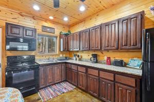 a kitchen with wooden cabinets and a black stove at Quail Cove Oak Premium Lakefront Condo Boat Slip in Shell Knob