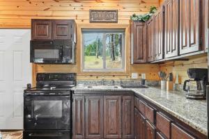 a kitchen with wooden cabinets and a black appliances at Quail Cove Oak Premium Lakefront Condo Boat Slip in Shell Knob