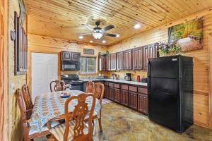 a kitchen with a table and a black refrigerator at Quail Cove Oak Premium Lakefront Condo Boat Slip in Shell Knob
