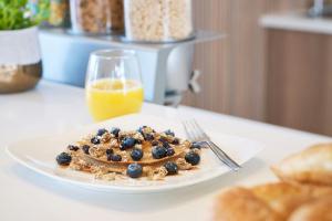a plate of pancakes with blueberries and a glass of orange juice at Element by Marriott San Diego Chula Vista in Chula Vista