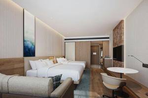 a hotel room with two beds and a couch at Fairfield by Marriott Changchun Chaoyang in Changchun +28 photos