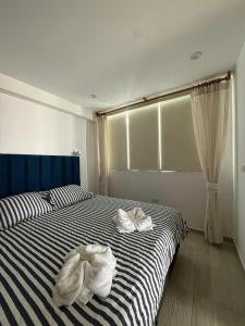 a bedroom with two white towels on a bed at Ballestas Suite in Pisco