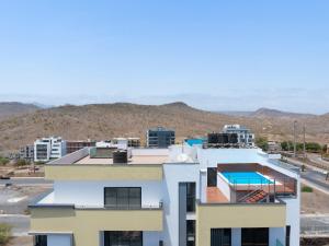 a white building with a swimming pool on top of it at Modern 2-bdr apt with rooftop pool - LCGR in Praia