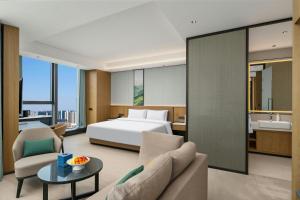 a hotel room with a bed and a couch and a table at Fairfield by Marriott Yulin in Yulin