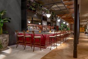 a bar with chairs and a red counter at The Eliza Jane, Autograph Collection in New Orleans